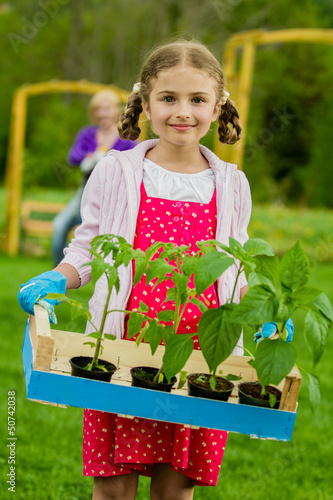 Photo: Gardening, planting - lovely girl working in vegetable garden Gardening, planting - lovely girl working in vegetable garden