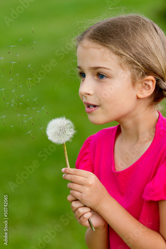 Photo: Summer joy - lovely girl blowing dandelion Summer joy - lovely girl blowing dandelion