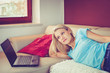 Photo: Pretty Young Girl Lying on a Sofa by Her Laptop Pretty Young Girl Lying on a Sofa by Her Laptop
