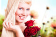 junge blonde Frau mit Rosen vor Frühlingshintergrund
