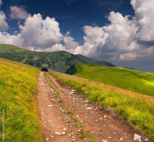 Photo: Offroader on the mountain road at summer Offroader on the mountain road at summer