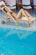 Pretty young woman relaxing by the pool
