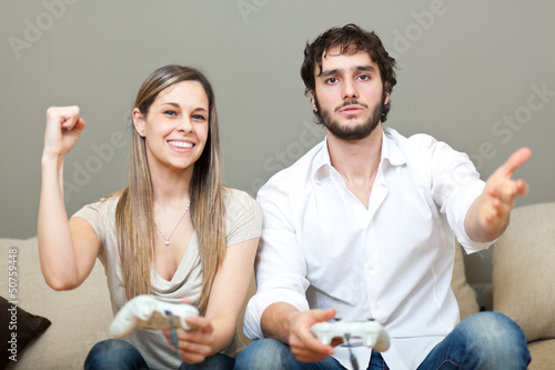 Photo: Couple playing video games at home Couple playing video games at home