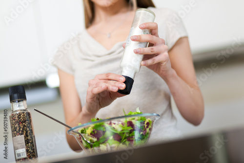 Photo: Woman preparing a salad at home Woman preparing a salad at home
