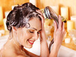 Woman washes her head at bathroom.