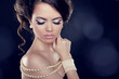 Beautiful woman with a pearl necklace on the bared shoulders