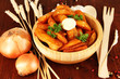 Appetizing village potatoes in bowl on wooden table close-up