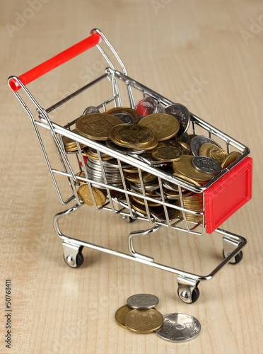 Photo: Money in cart on wooden table close-up Money in cart on wooden table close-up