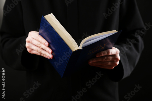 Photo: Priest reading from the holy bible, close up Priest reading from the holy bible, close up
