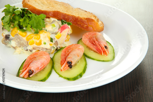 Photo: Small portion of food on big plate on wooden table Small portion of food on big plate on wooden table