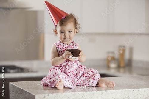 Photo: Beautiful baby girl eating cake for her birthday Beautiful baby girl eating cake for her birthday