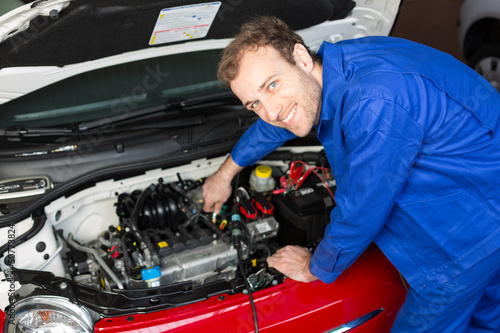 Photo: Mechanic repairing a car in a workshop or garage Mechanic repairing a car in a workshop or garage