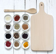 Spices and dried vegetables with cutting board on white planks