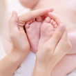 Baby feet cupped into mothers hands