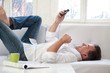 Foto: Mann auf dem Sofa liegend mit Smartphone Mann auf dem Sofa liegend mit Smartphone