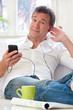 Foto: Mann hört auf der Couch Musik Mann hört auf der Couch Musik