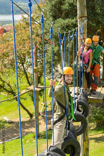 Photo: Smiling man climbing in adventure park Smiling man climbing in adventure park