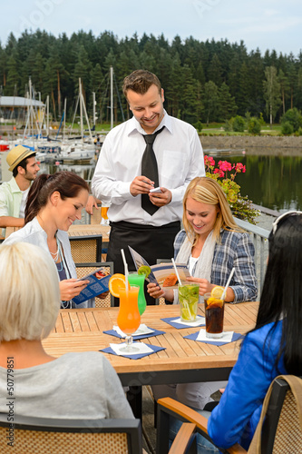 Photo: Waiter taking orders sidewalk bar from women Waiter taking orders sidewalk bar from women