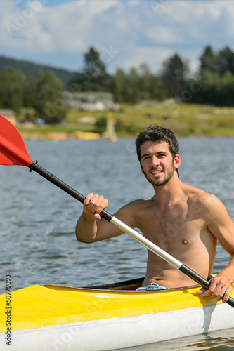 Photo: Smiling sporty man kayaking on lake Smiling sporty man kayaking on lake