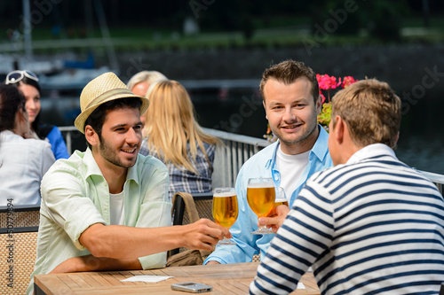 Photo: Three male friends drinking beer outdoor terrace Three male friends drinking beer outdoor terrace