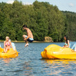 Young man jumping into water paddle boat