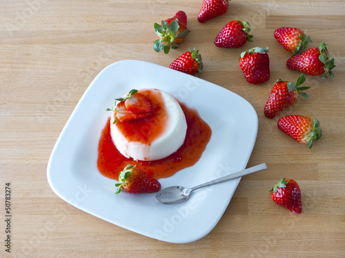 Photo: Panna Cotta auf einem Teller und Holzbrett Panna Cotta auf einem Teller und Holzbrett