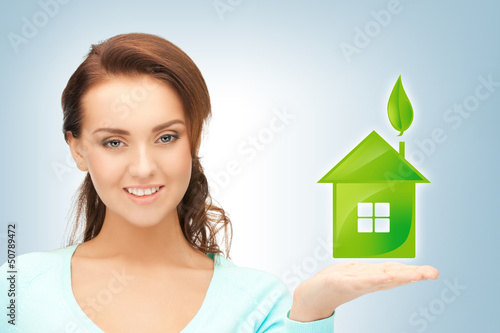 Photo: woman holding green house in her hands woman holding green house in her hands