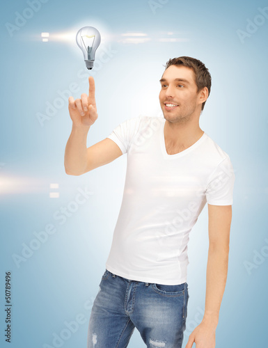 Photo: handsome man pointing at light bulb handsome man pointing at light bulb