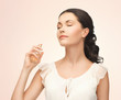 woman spraying perfume on her neck