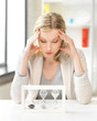 tired woman behind the table with hourgalss