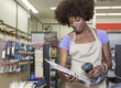 Foto: Portrait of an African American female store clerk standing at checkout counter scanning item Portrait of an African American female store clerk standing at checkout counter scanning item