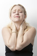 Photo: Young Caucasian woman suffering from neckache standing against white background Young Caucasian woman suffering from neckache standing against white background