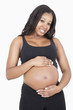 Photo: Portrait of happy young pregnant woman with hands on stomach over white background Portrait of happy young pregnant woman with hands on stomach over white background