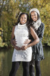 Photo: Portrait of young pregnant woman with female friend spending quality time in park Portrait of young pregnant woman with female friend spending quality time in park