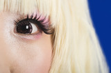 Photo: Close-up portrait of cute young woman's face with blond hair against blue background Close-up portrait of cute young woman's face with blond hair against blue background