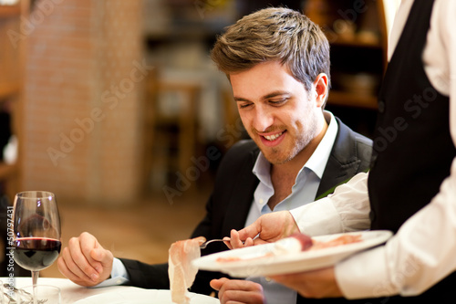 Photo: Waiter serving ham to a customer Waiter serving ham to a customer
