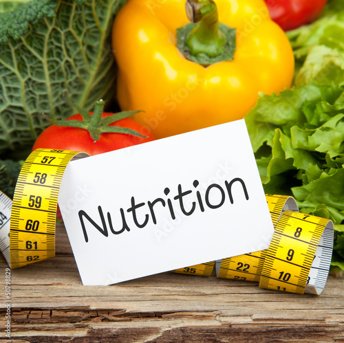 Photo: Gemüse auf Holz mit Zettel und Massband NUTRITION Gemüse auf Holz mit Zettel und Massband NUTRITION