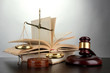 Golden scales of justice, gavel and books on grey background