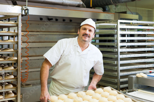 Photo: Male baker baking bread rolls Male baker baking bread rolls