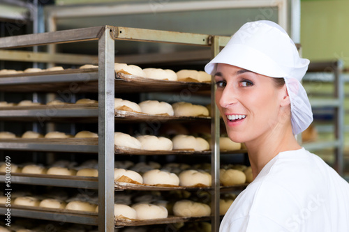 Photo: Female baker baking bread rolls Female baker baking bread rolls