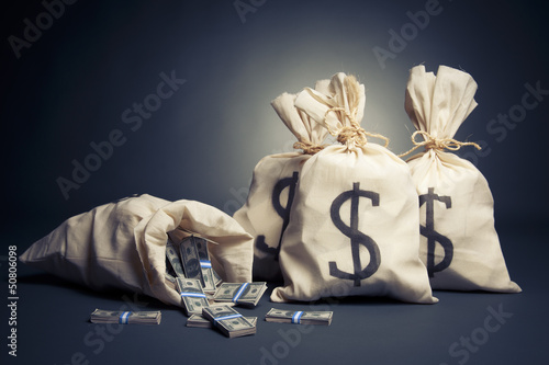 Photo: Bags full of money on a dark background Bags full of money on a dark background