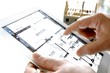 Tablet mit Rohbau und Bauplan in Händen