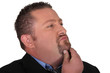 Businessman stroking his beard whilst thinking