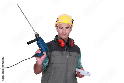 Photo: Man holding drill and plans Man holding drill and plans
