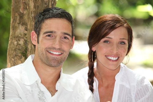 Photo: Couple in front of a tree trunk Couple in front of a tree trunk