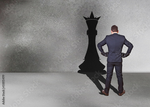 Photo: businessman with chess king shadow businessman with chess king shadow