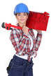 A female manual worker with a toolbox and a wrench.
