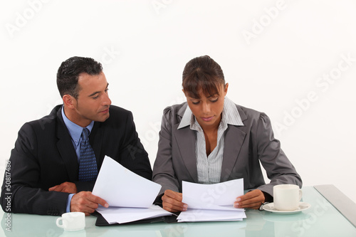 Photo: Business professionals reviewing reports Business professionals reviewing reports