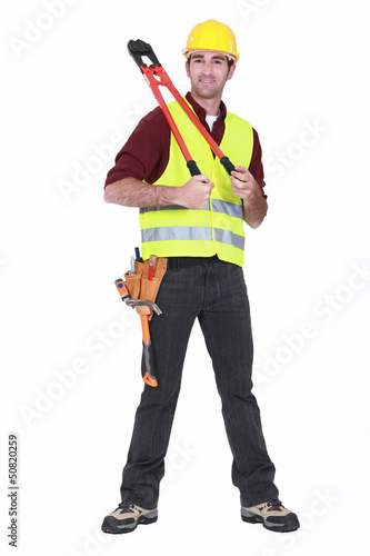 Photo: Man wearing a hard hat and holding large clippers Man wearing a hard hat and holding large clippers