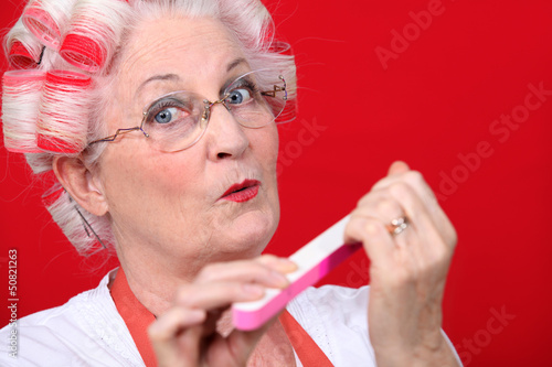 Photo: Elderly woman filing her nails Elderly woman filing her nails